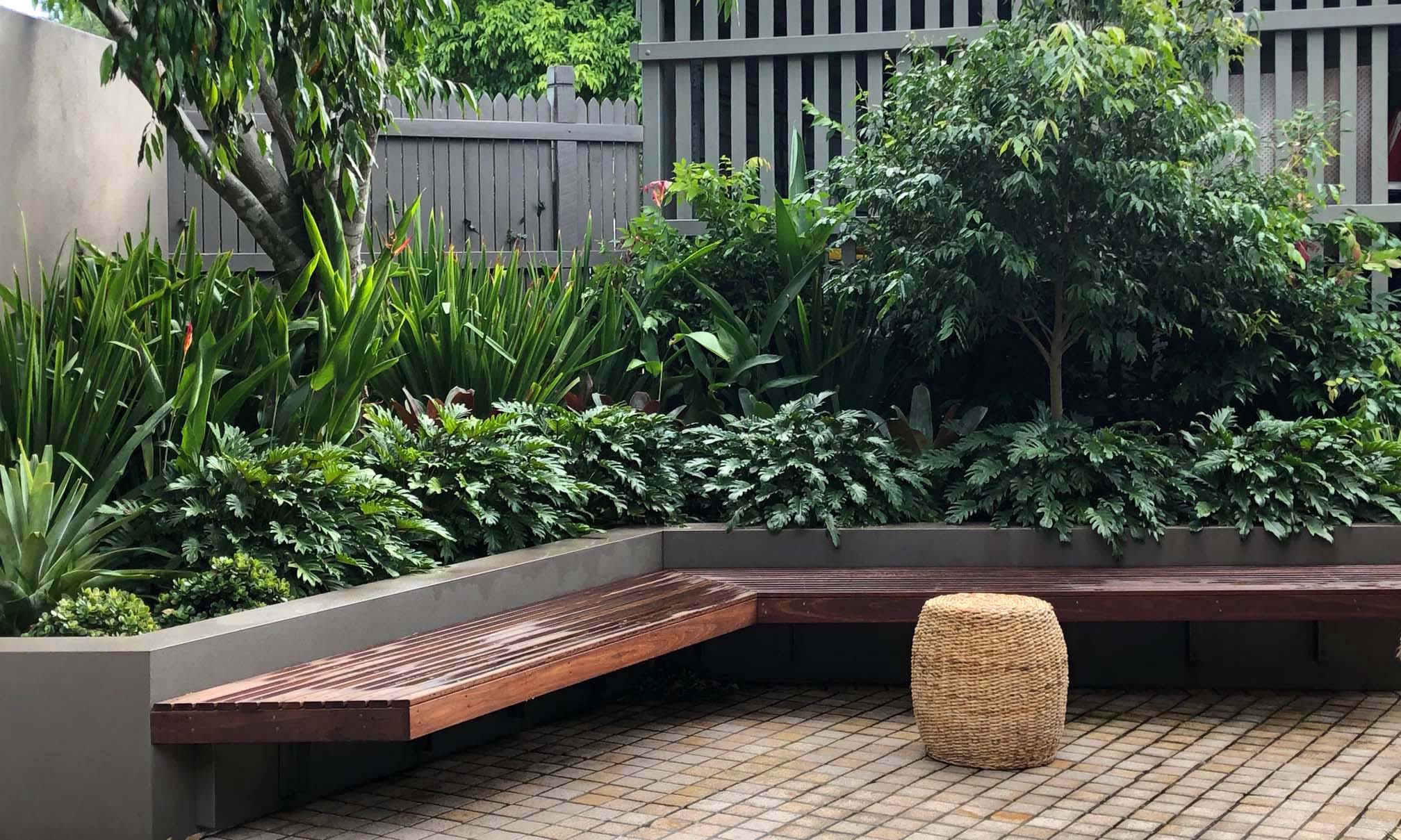rendered wall, floating bench and cobblestone pavers